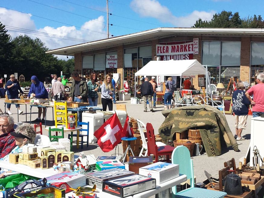 Vendors and shoppers at an outdoor flea market