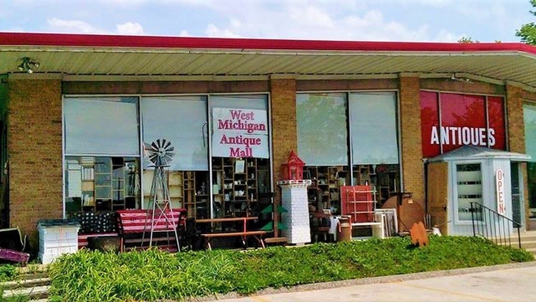 The entrance to West Michigan Antique Mall, with its red antiques sign and vintage porch finds